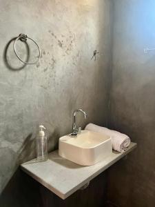 a bathroom sink with a soap dispenser on a shelf at Casa Pôr do Sol in Guriú