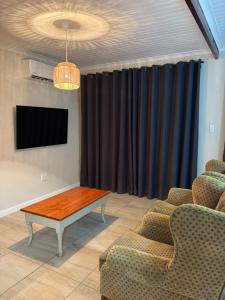 a living room with a table and a black curtain at Worcester accommodation Putt and Stay in Worcester