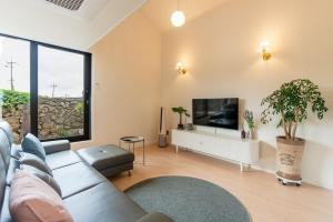 a living room with a couch and a flat screen tv at In Aewol Forest 102 in Haean