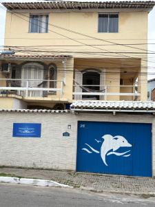 a building with a blue garage door with a fish on it at Pousada Recanto do Arraial do Cabo in Arraial do Cabo