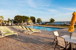 a pool with chairs and tables and a yellow umbrella at The Citrus Hotel in Tavares