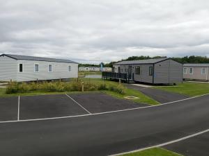 a parking lot with two houses and a tennis court at Lakeland Leisure Park - Holiday Accommodation 20349 in Flookburgh