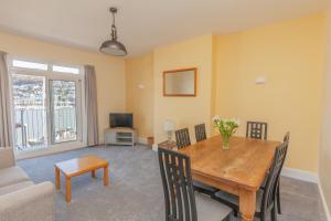 a living room with a wooden table and chairs at Harbourside 2 in Dartmouth