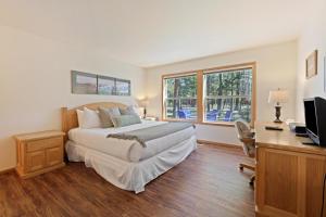 a bedroom with a bed and a desk with a computer at 1 Colonial in Sunriver