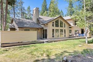 a house with a fence in front of a yard at 1 Colonial in Sunriver