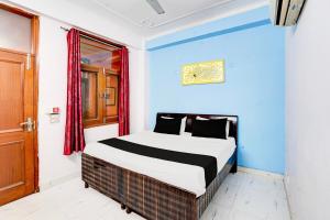 une chambre avec un lit dans une pièce bleue dans l'établissement Hotel O The Swarnim, à Noida