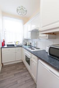 a kitchen with white cabinets and a black counter top at Harbourside 2 in Dartmouth