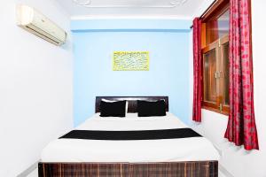 une chambre avec un lit dans une pièce bleue dans l'établissement Hotel O The Swarnim, à Noida 20 autres photos