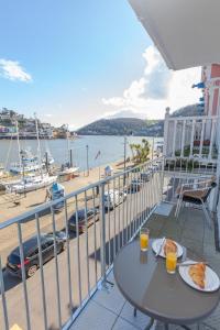 a table with two plates of food on a balcony with a beach at Harbourside 2 in Dartmouth