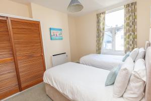 a bedroom with two beds and a window at Harbourside 2 in Dartmouth