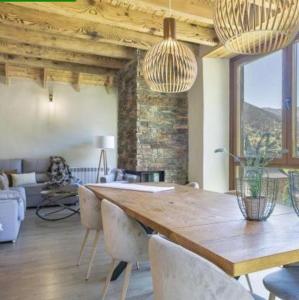 サラルドゥにあるEth Estel de Salardú--Casa con vistas de ensueño-Fibra Optica,5TVの大きな木製のテーブルと椅子のあるリビングルーム