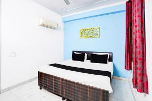 une chambre avec un lit avec un mur bleu dans l'établissement Hotel O The Swarnim, à Noida