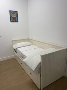 a bed in a room with a white wall at Casa ARANAL in Málaga