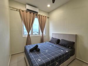 a bedroom with a bed with a blue comforter and a window at D Aman Infinity Pool and AS Tower View Homestay 05 in Alor Setar +93 photos