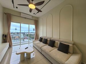 a living room with a couch and a large window at D Aman Infinity Pool and AS Tower View Homestay 05 in Alor Setar