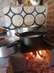 Una olla se está cocinando sobre el fuego en una cocina. en Sítio Doce Mel, en Saquarema