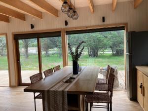 a dining room table with chairs and a large window at Preciosa casa V. Cerro Castillo cercana Parque in Villa Cerro Castillo +31 photos
