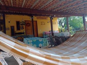 a hammock in a patio with a table and chairs at Sítio Doce Mel in Saquarema