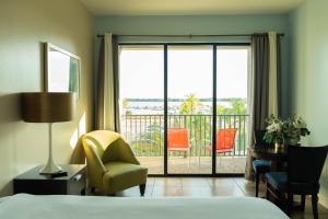 a hotel room with a bed and a balcony at The Citrus Hotel in Tavares +70 photos