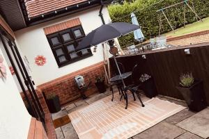 a patio with a table and an umbrella at Claverley Hideaway Sleeps 2 with Patio in Wolverhampton