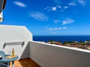 Un balcón con mesa y vista al mar. en Vivienda Vacacional El Zumacal, en San Antonio