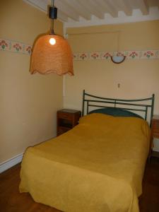 een slaapkamer met een geel bed en een lamp bij Les Grands-Parents in Corancy