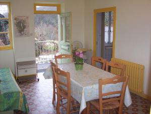 a dining room with a table and chairs and a window at Les Grands-Parents in Corancy