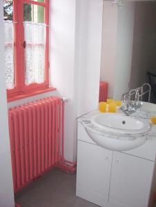 een badkamer met een rode radiator en een wastafel bij Les Grands-Parents in Corancy