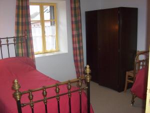een slaapkamer met een rood bed en een raam bij Les Grands-Parents in Corancy