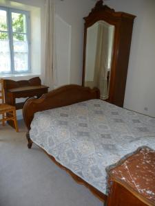 een slaapkamer met een bed en een grote spiegel bij Les Grands-Parents in Corancy