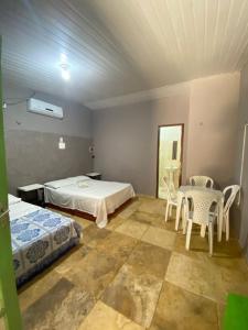 a bedroom with a bed and a table and chairs at Condomínio em Canoa Quebrada in Aracati