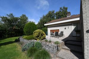 einen Hinterhof mit einer steinernen Mauer und einer Terrasse in der Unterkunft Vrijvakantiehuis Rooistrand in Burgh Haamstede