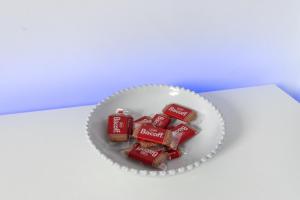 a white bowl filled with chocolates on a table at Charming 3 Bed House with Garden in Bickley