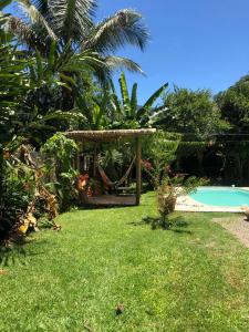 a garden with a gazebo and a swimming pool at Suíte Recanto bom Sossego in Ubatuba