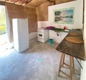 a kitchen with a refrigerator and a table in it at Condomínio em Canoa Quebrada in Aracati