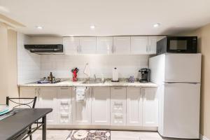 a kitchen with white cabinets and a white refrigerator at Modern Suite Condo Heart Of St Clair West - Bloor Hotel in Toronto