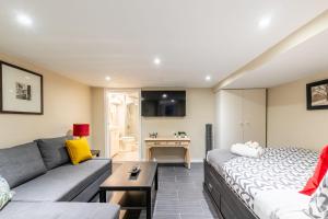 a living room with a couch and a table at Modern Suite Condo Heart Of St Clair West - Bloor Hotel in Toronto