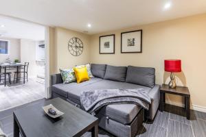 a living room with a couch and a table at Modern Suite Condo Heart Of St Clair West - Bloor Hotel in Toronto +4 photos