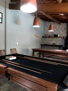 a pool table in a room with chairs and lights at Suíte Recanto bom Sossego in Ubatuba