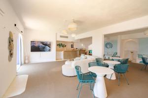 奇波斯阿费提Poseidon Blue Gastronomy Hotel的一间带桌椅的客厅和一间厨房 更多68张照片