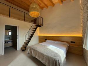 a bedroom with a bed and a stair case at Mas Les Arrabassades in Castelló d'Empúries