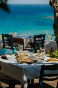 una mesa con platos de comida en la playa en Poseidon Blue Gastronomy Hotel, en Afiartis