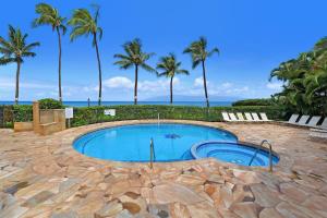 a swimming pool with palm trees and the ocean at Paki Maui 301 · Direct Oceanfront Views Remodeled 2BD Condo in Kahana
