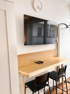a wooden table with two chairs and a tv on a wall at Quiet Stay and Parking in Prague