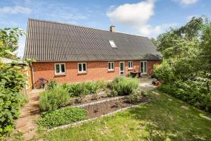 HesselagerDejlig Feriebolig I Hesselager På Charmerende Sydfyn的前面有花园的砖房