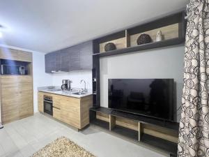 Una cocina con un televisor de pantalla plana grande junto a una encimera en Concep Centro Freiré-Tucapel, en Concepción