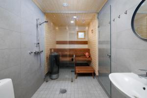a bathroom with a shower and a bench and a sink at Porevillas Iso-Syöte B in Syöte