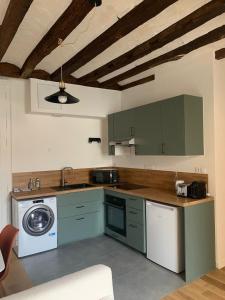 a kitchen with green cabinets and a washing machine at Le Sauge in Angers