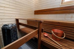 a wooden sauna with a bucket and a bucket at Porevillas Iso-Syöte B in Syöte