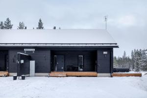 a black building with snow on the ground at Porevillas Iso-Syöte B in Syöte +43 photos